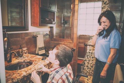 mid-30os-asian-women-smiling-at-yound-caucasian-boy-looking-upward-toward-top-shelf-in-houses-