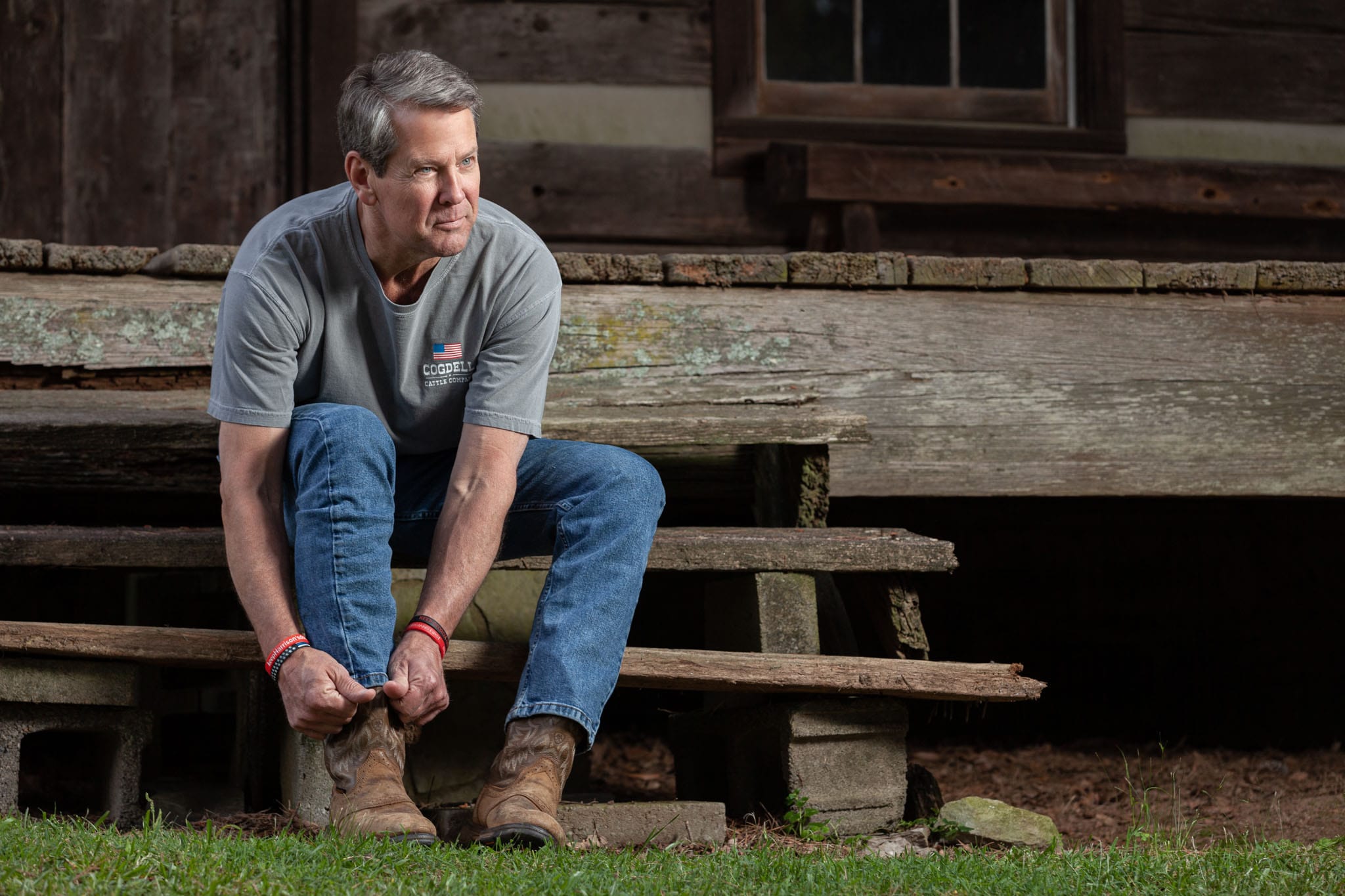 Georgia Governor Brian Kemp putting on his boots on the steps of his family's historical log cabin in Athens, Georgia.