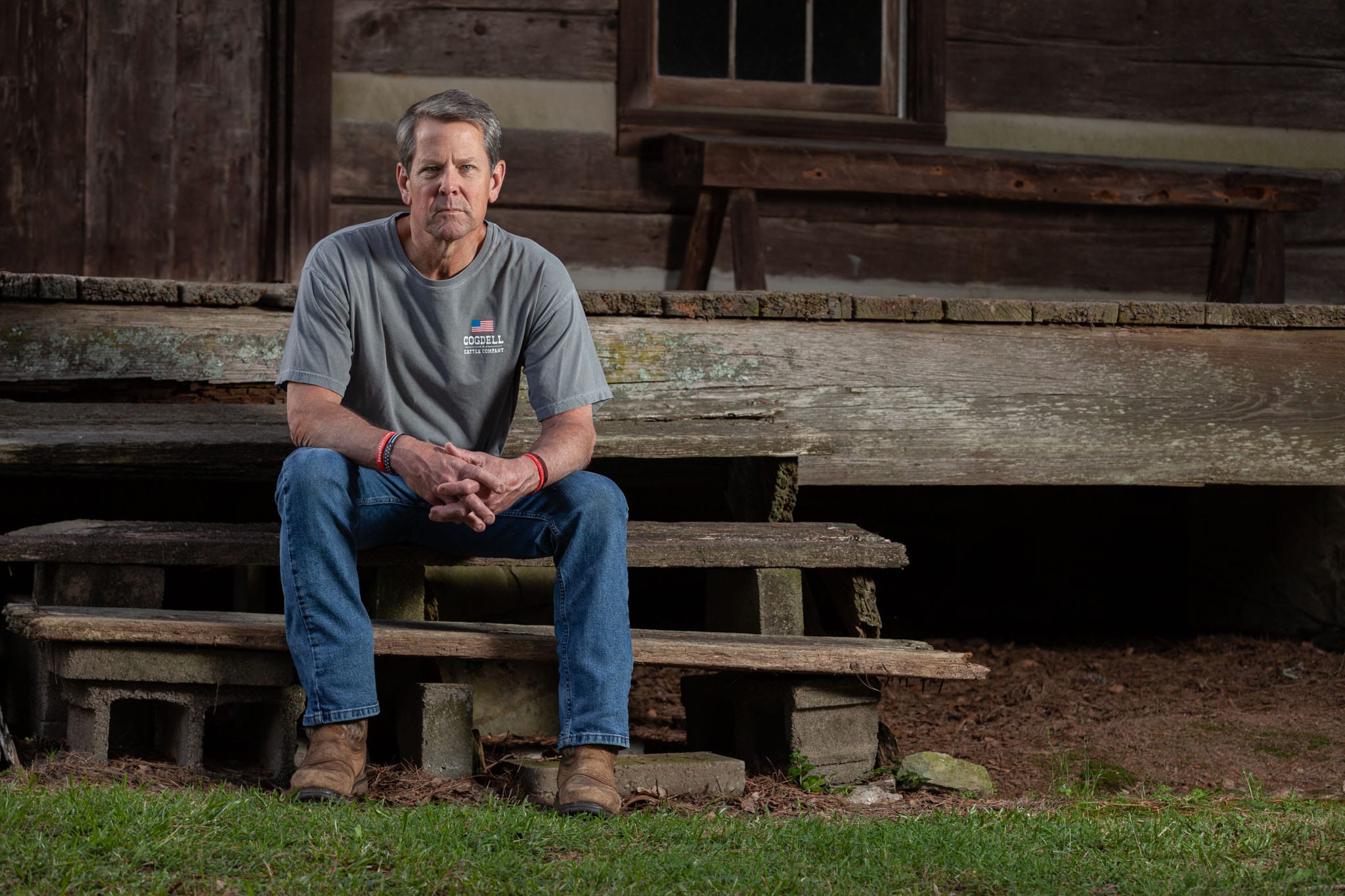 Georgia Governor Brian Kemp sitting on the steps of his family's historical cabin in Athens, Georgia.