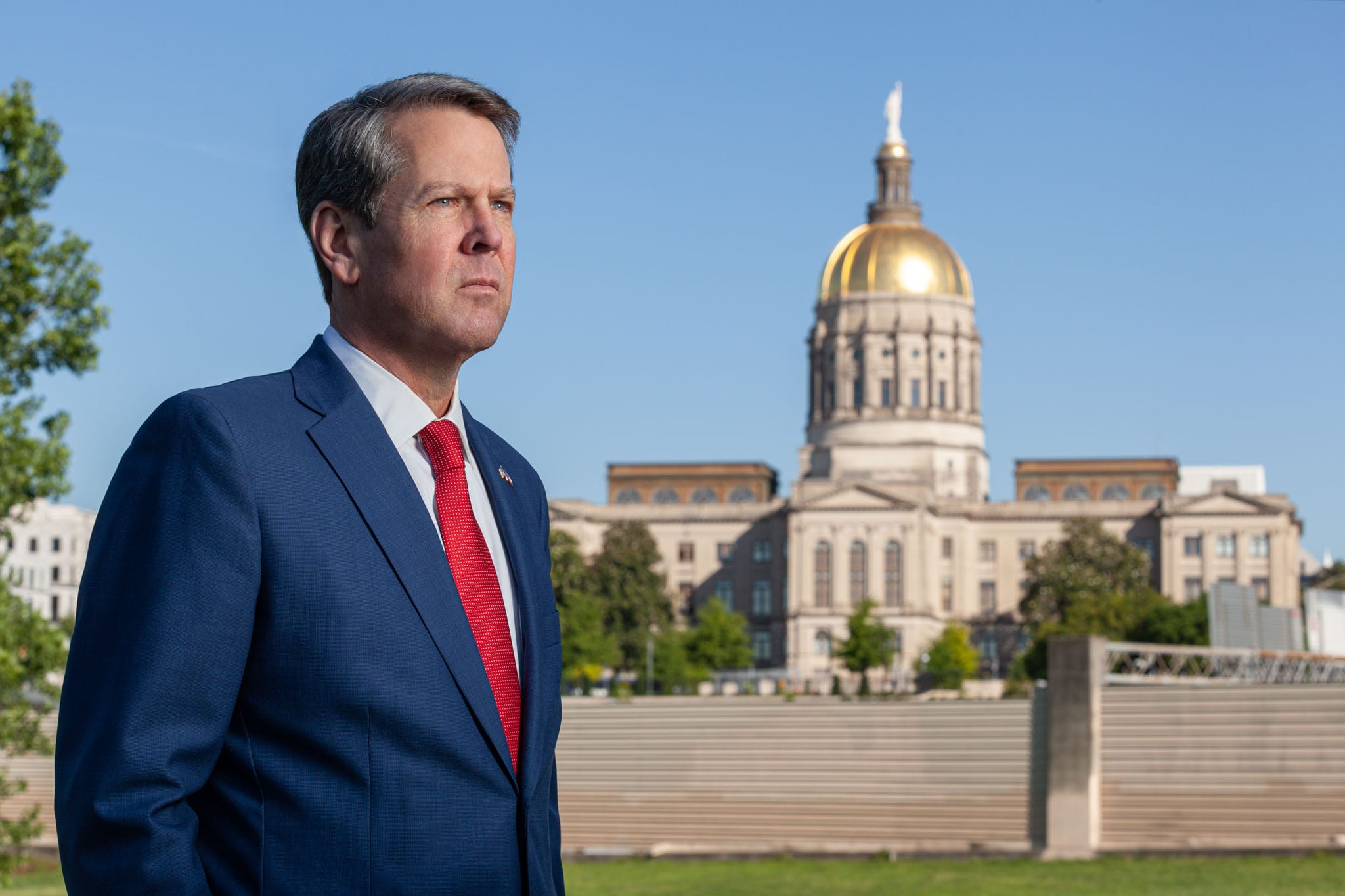 Georgia Governor Brian Kemp staring sternly in front of the Georgia State Capitol.