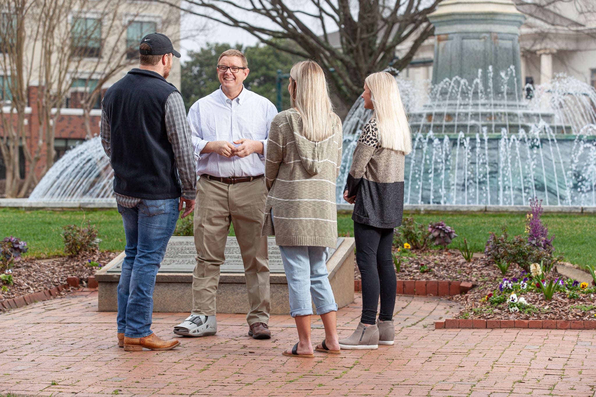 Georgia-State-Representative-and-helicopter-pilot-David-Jenkins-standing-in-front-of-a-water-fountain-in-a-city-park-talking-to-a-young-man-and-two-young-women.