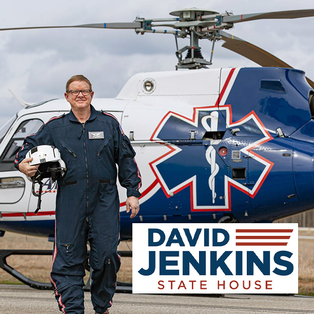 david-jones-mid-50s-male-facing-forward-in-medic-pilot-and-attire-whilst-medic-helicopter-is-in-the-background-