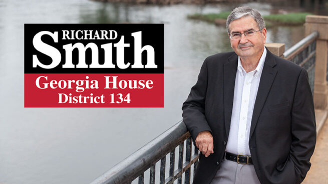 Georgia-Representative-Richard Smith-leaning-against-an-riverwalk-arm-rail-with-the-Chattahoochee-River-in-Columbus-Georgia-in-the-background