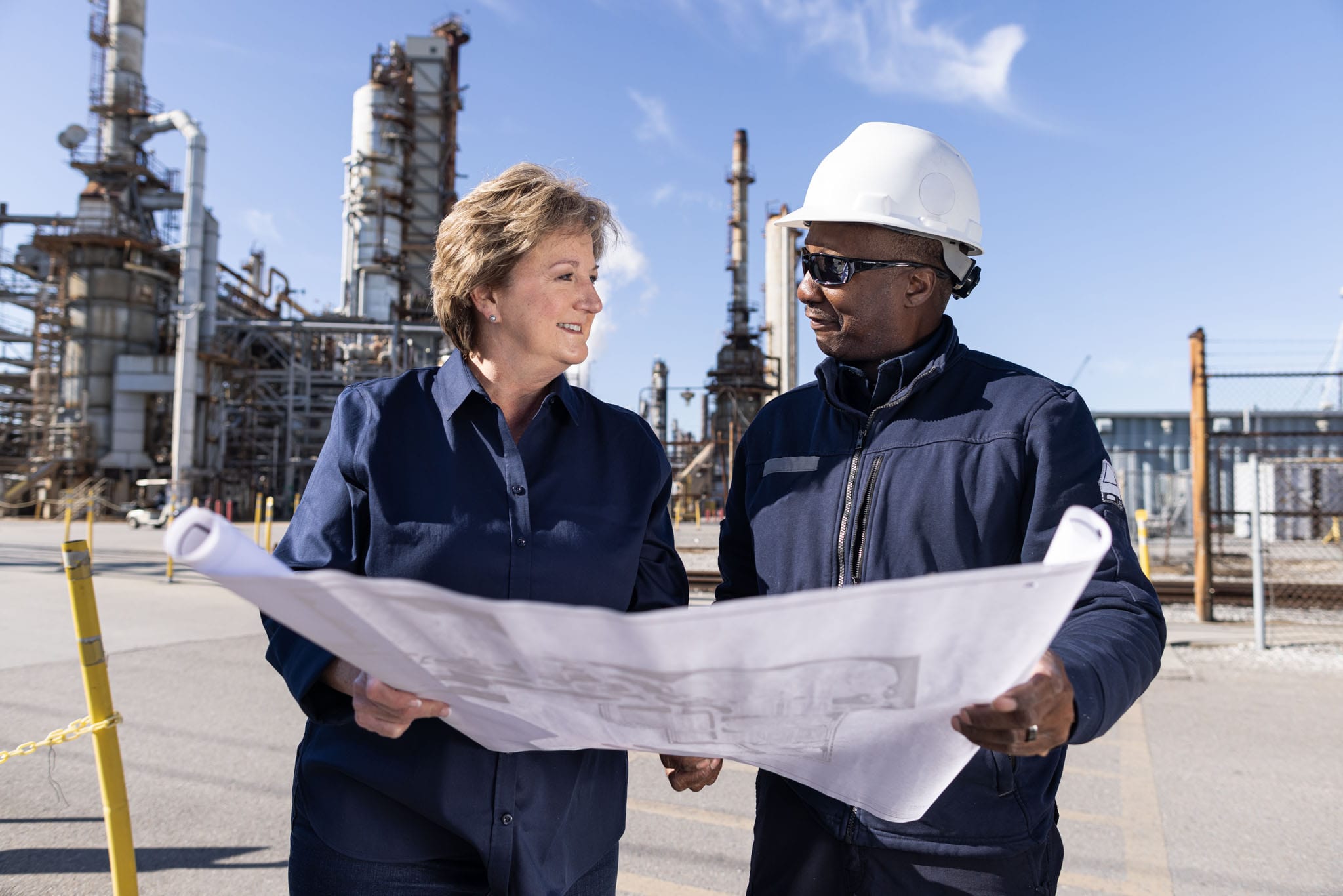 sharon-hewitt-mid-sixties-caucasian-woman-with-african-american-oil-refinery-worker-whilst-holding-map-plan
