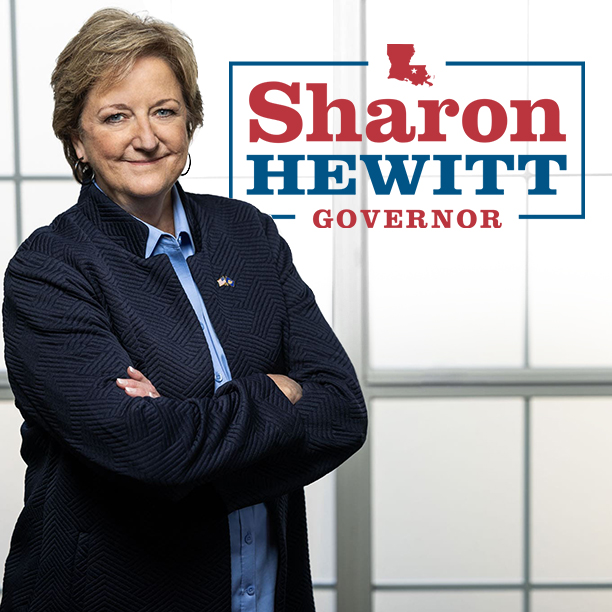 Mid-sixties-Caucasian-woman-wearing-a-blue-jacket-with-arms-crossed-smiling-at-the-camera-who-is-running-for-Louisiana-Governor.